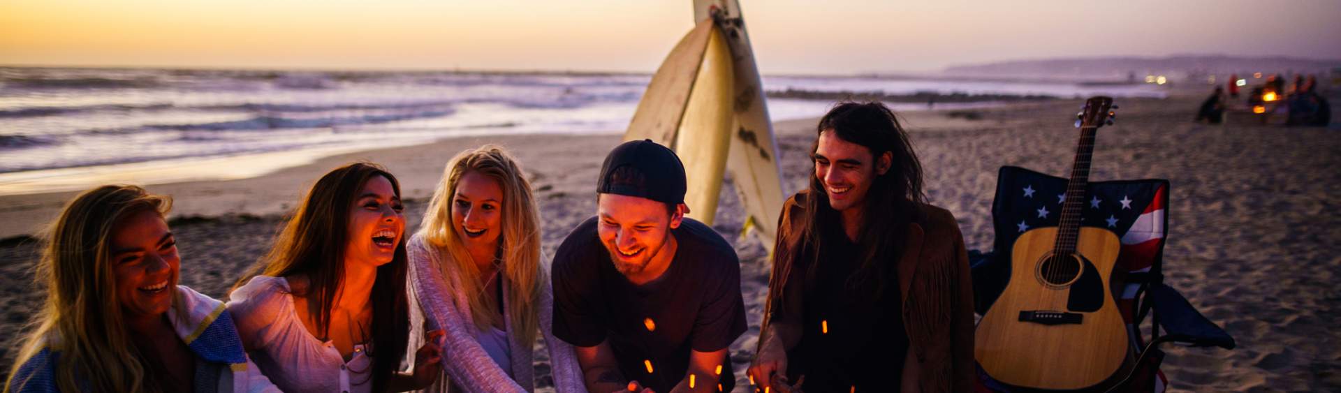 People gathered around a beach fire pit